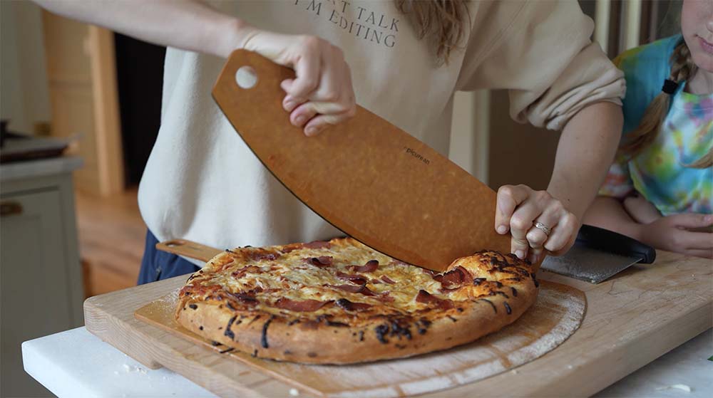 woman cutting homemade pizza 